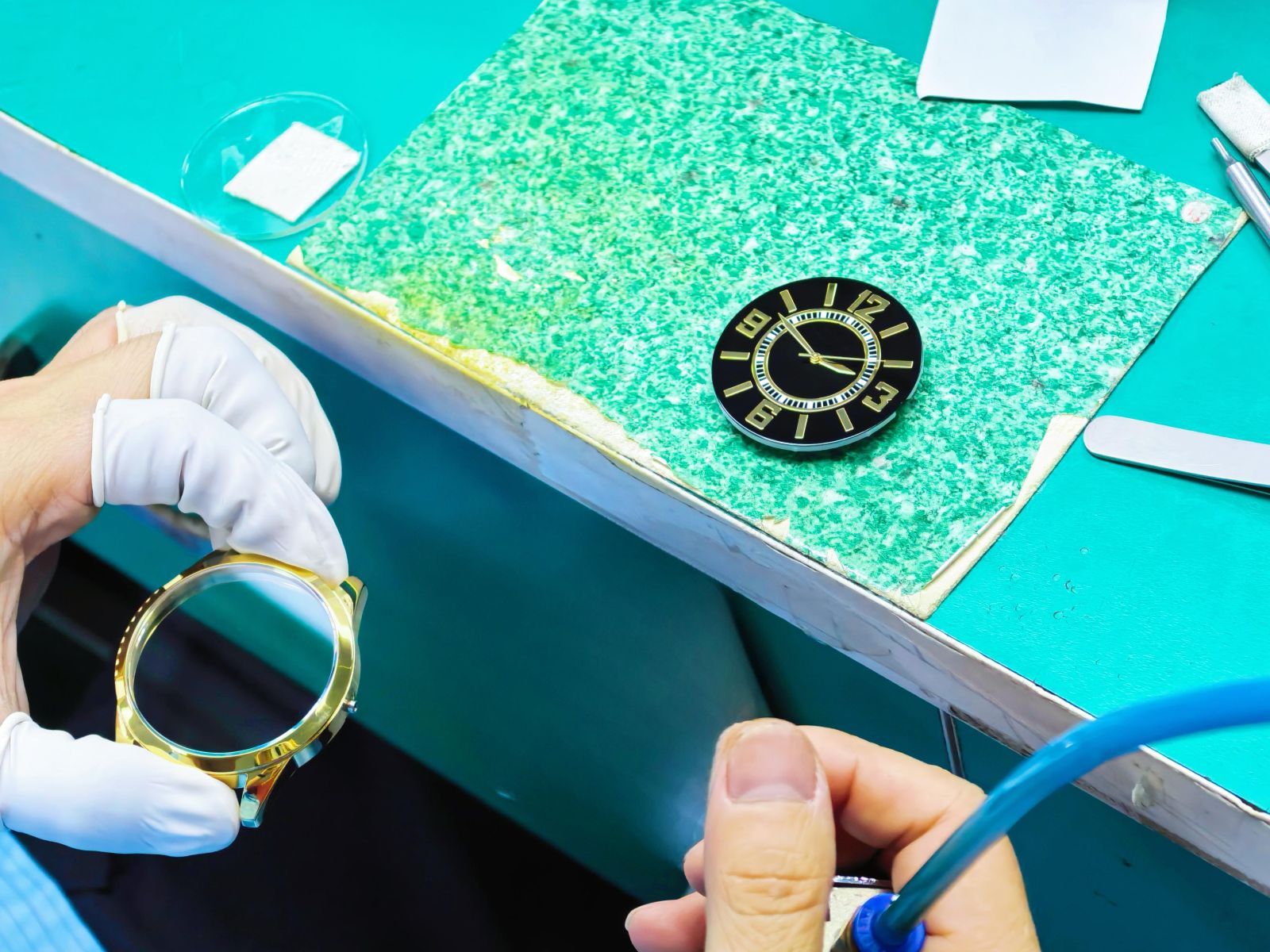 Technician cleaning watch components before the next assembly step.